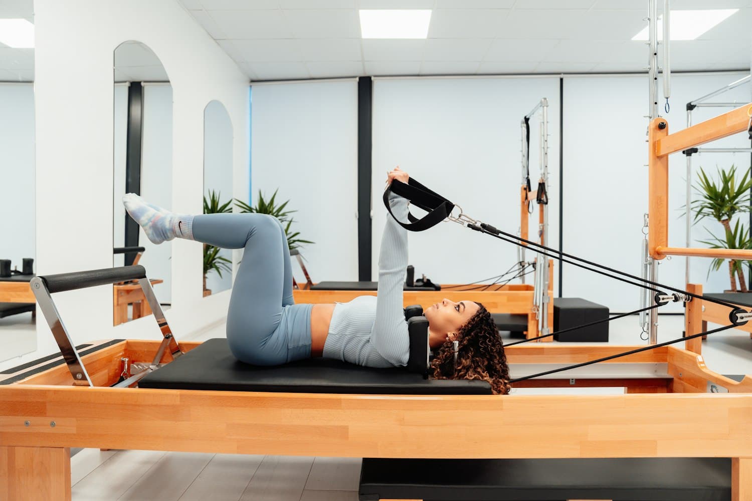 Reformer Pilates studio interior, sunlit and minimal