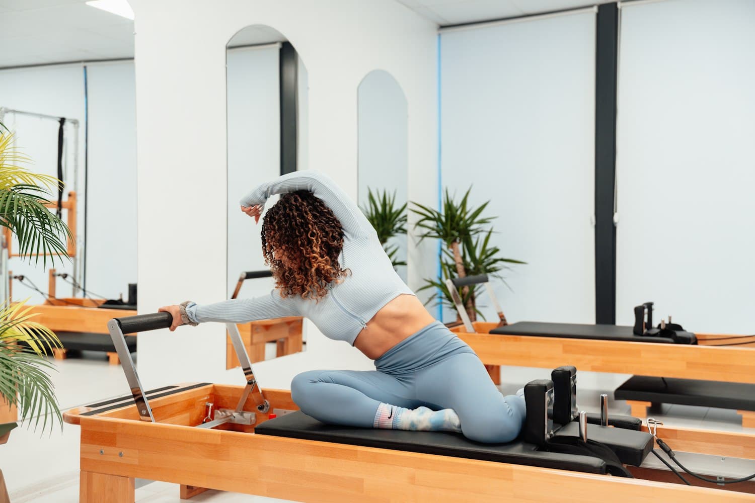 Instructor guiding a client through reformer Pilates